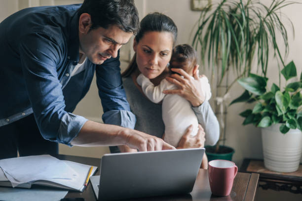 Parents reviewing coverage options on a laptop while holding their baby